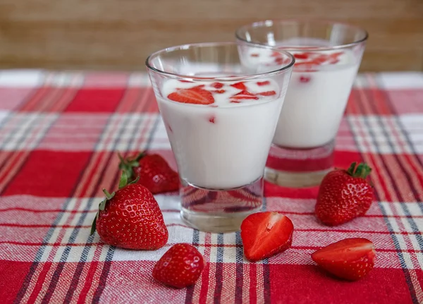 Two Glasses of Yogurt,Red Fresh Strawberries on the Check Tablecloth.Breakfast Organic Healthy Tasty Food.Cooking Vitamins Ingredients.Summer Fruits.Selective Focus