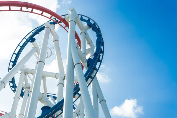 A roller coaster\'s loop with blue sky