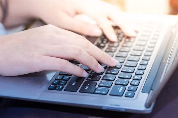 Women hands typing on laptop keyboard