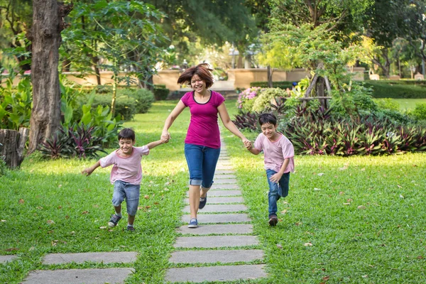 Mother running in the park with sons