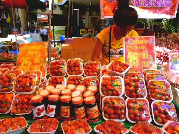Street vendor selling strawberries at market