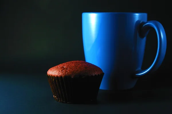 Chocolate cupcake and blue mug