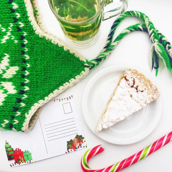 Tea with mint and cake near the green hat and a letter to Santa Claus