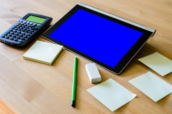 Workplace with tablet pc - blue box, calculator, pencil and stic