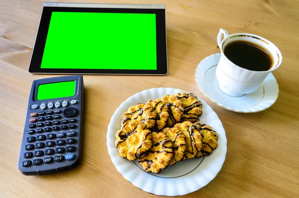 Workplace with tablet pc - green box, calculator, cup of coffee