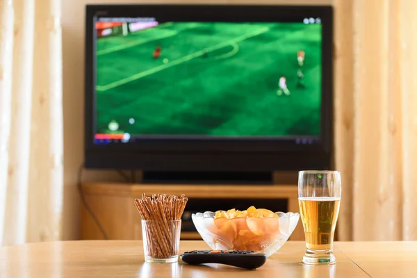 Television, TV watching (football, soccer match) with snacks lyi