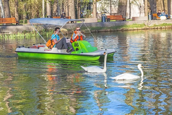 Couple riding catamaran in pond