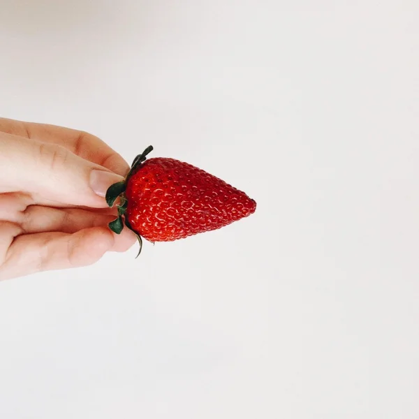 Ripe juicy strawberry in hand