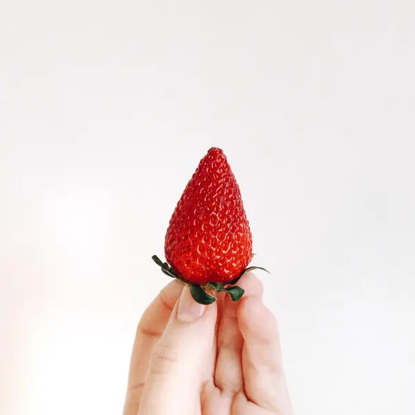 Ripe juicy strawberry in hand