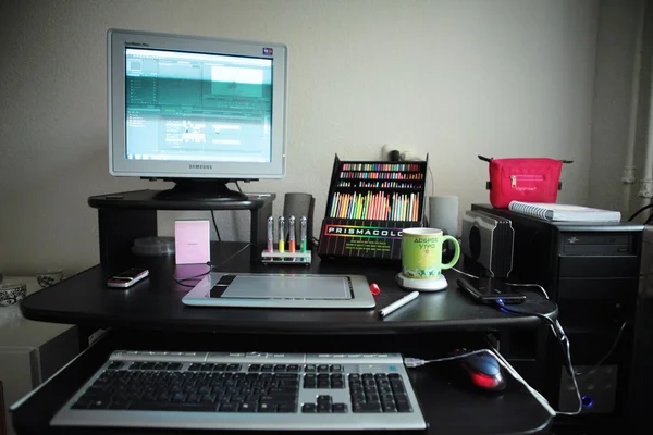 Computers, cup of tea and pencils on table