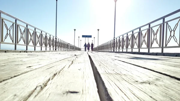 People walking over wooden bridge