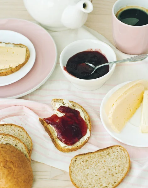 Coffee and bread with butter and jam