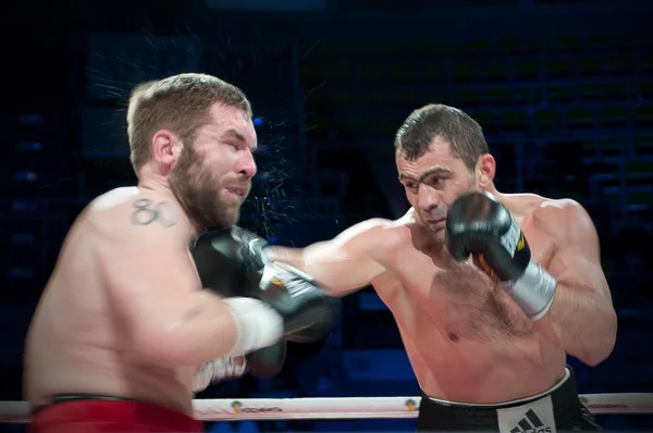 Boxers fighting on boxing ring