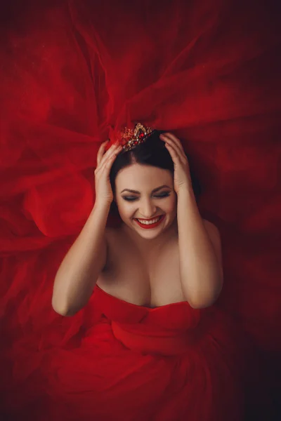 Gorgeous woman in red dress with crown