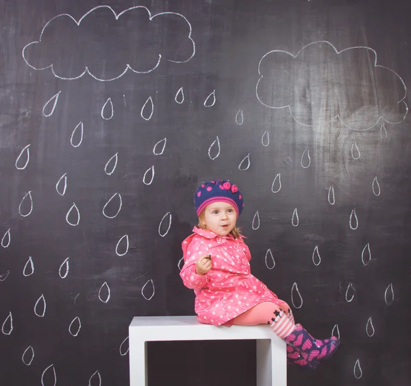 Little girl in pink raincoat