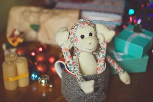 Christmas still life with toy monkey in knitted cup