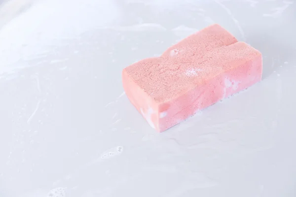 Soaky pink sponge on a surface of car