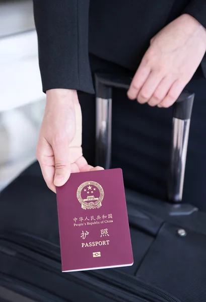 Hand holding China passport, ready to travel