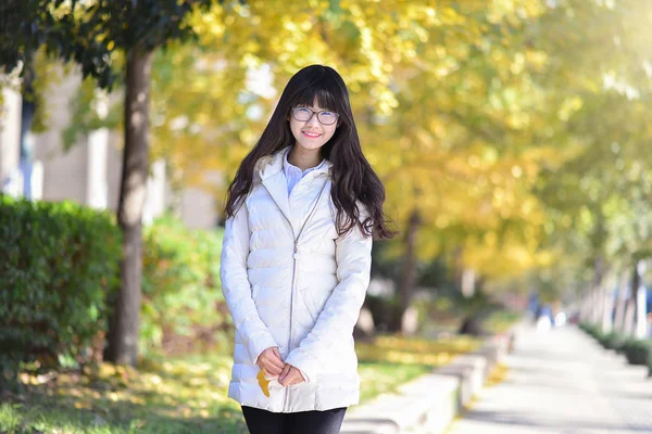 Pretty Chinese girl dresses down coat in the sunshine day