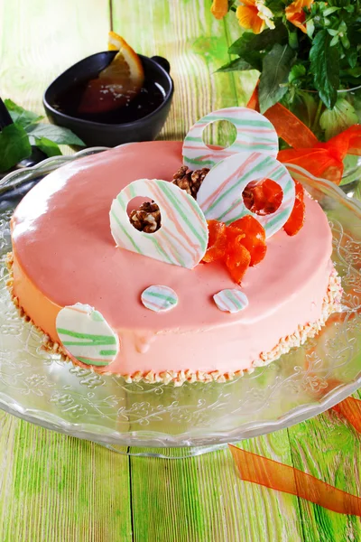 Carrot cake in pink icing decorated with white chocolate still life plank wooden table decorations Dried carrots romantic spring flowers fresh tape