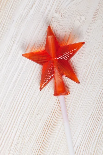 Candy caramel transparent red star on the wooden table white board