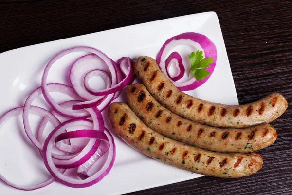 Grilled sausages with easy side dish of purple salad onion parsley