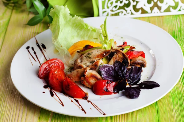 Beautiful salad with grilled chicken, mushrooms, vegetables, peppers, leeks in a still life on green chalkboard, elegant, fine dining, food, appetizing