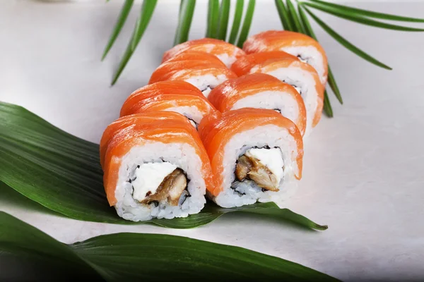 Philadelphia roll with eel salmon sushi food on a tropical palm leaves to the menu