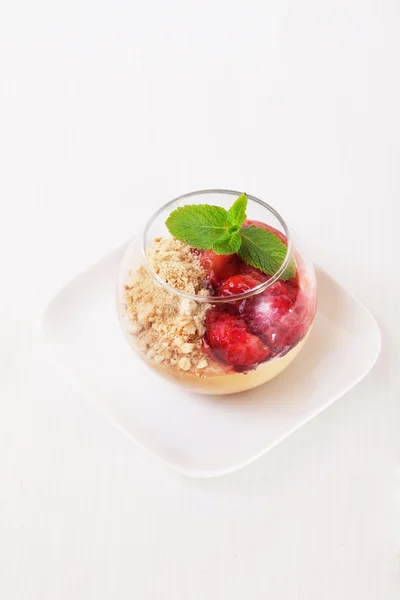Strawberry nut dessert in a glass with mint, crushed peanuts, walnuts