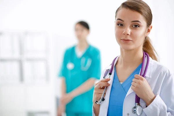 Attractive female doctor in front of medical group