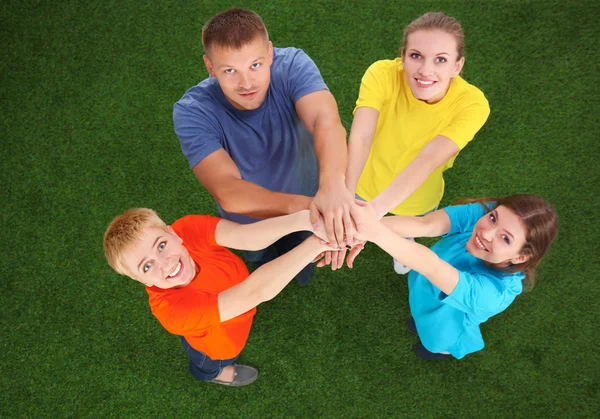 People joining their hands  on green grass