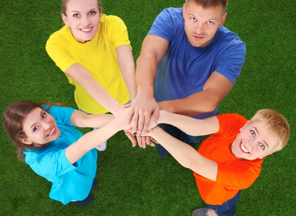 People joining their hands  on green grass