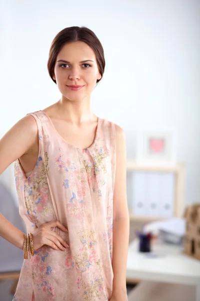 Close-up portrait of a smiling business woman standing in her office