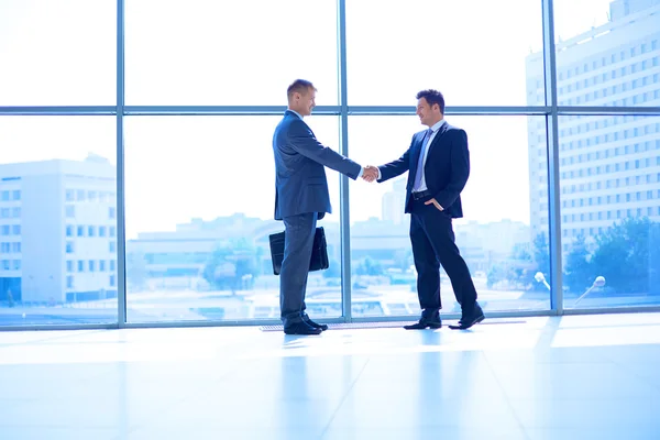 Full length image of two successful business men shaking hands with each other