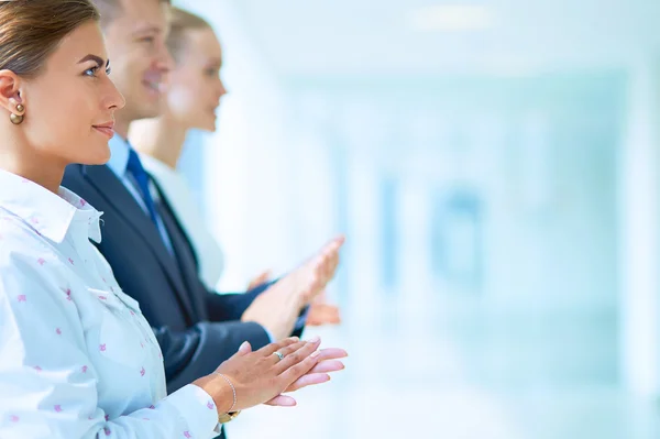 Smiling business people applauding a good presentation in the office