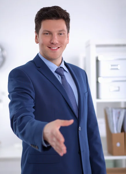 Business and office concept - handsome businessman with open hand ready for handshake