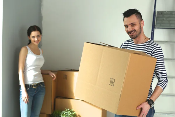 Happy young couple unpacking or packing boxes and moving into a new home