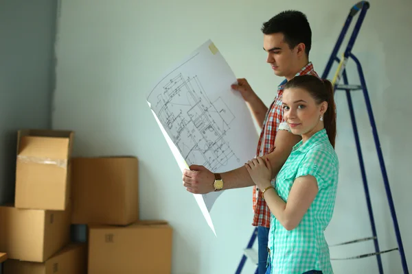 Portrait of young couple moving in new home with plane