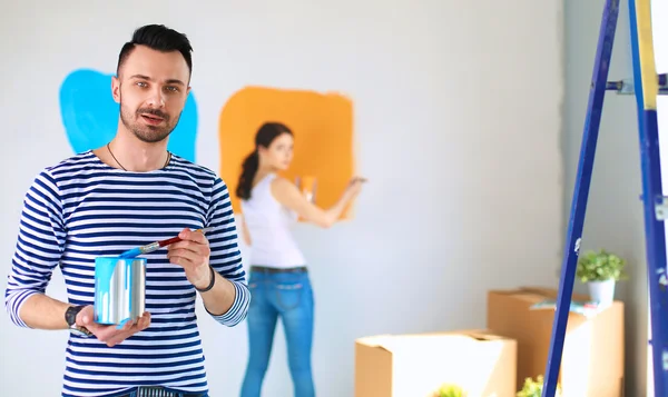 Portrait of happy smiling young couple  painting interior wall of new house