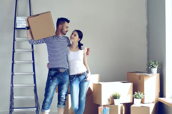 Happy young couple unpacking or packing boxes and moving into a new home