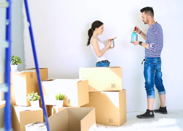 Portrait of happy smiling young couple  painting interior wall of new house