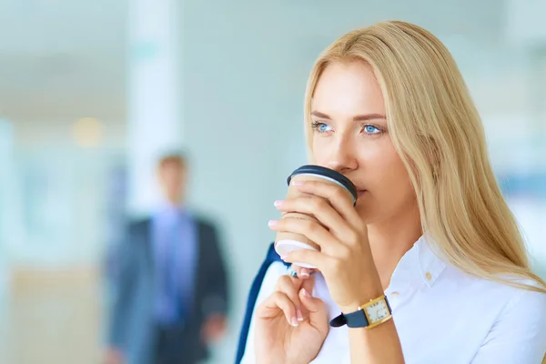 Yound woman drink coffee at office, standing