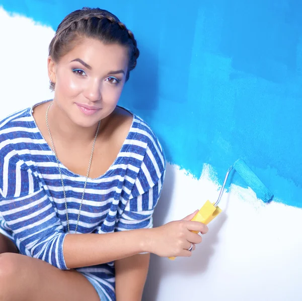 Happy beautiful young woman doing wall painting