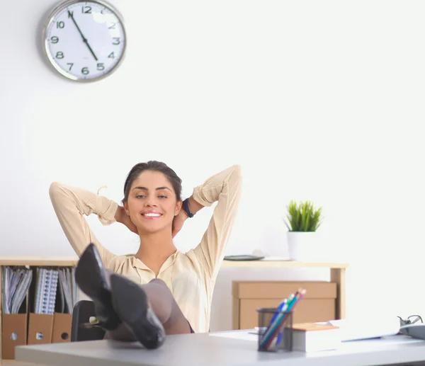 Business woman relaxing with hands behind her head and sitting on an office chair