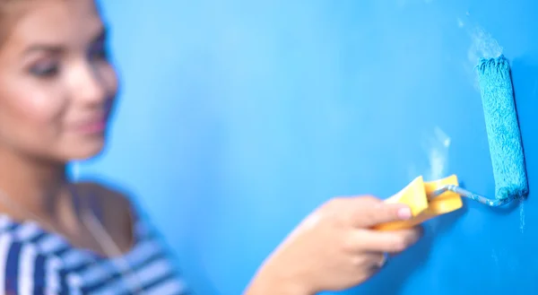 Happy beautiful young woman doing wall painting