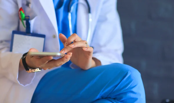 Young woman doctor sitting with your phone