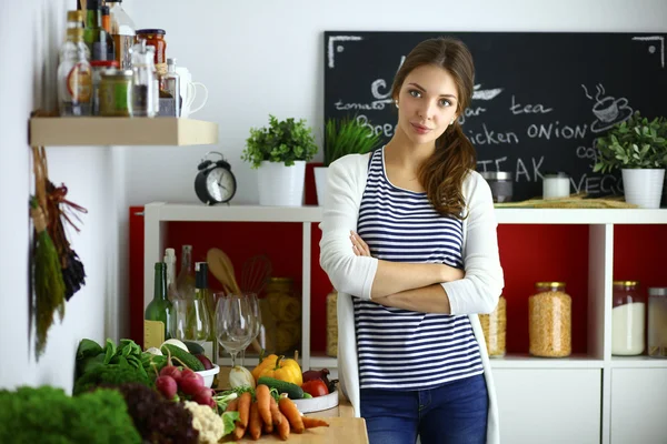 Young woman standing near desk in the kitchen