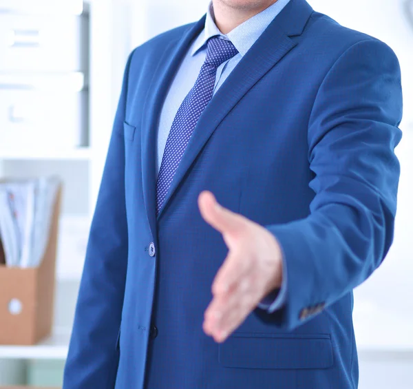 Business and office concept - handsome businessman with open hand ready for handshake