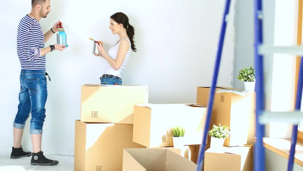 Portrait of happy smiling young couple  painting interior wall of new house