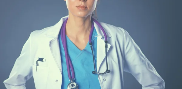 Young doctor woman with stethoscope isolated on grey